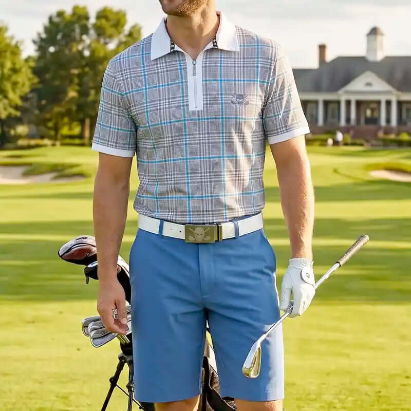 plaid golf outfit with shirt and blue shorts and white belt holding a golf club on a golf course.