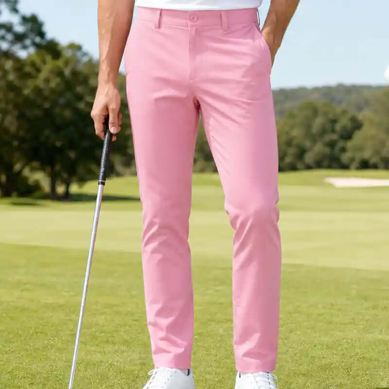 man wearing cool pink golf pants holding a golf club on a golf course