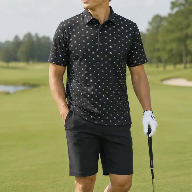 Man in black patterned polo shirt and shorts holding a golf club on a golf course.