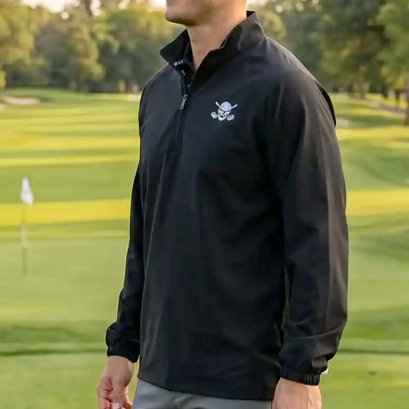 man wearing a black jacket with a skull logo on a golf course