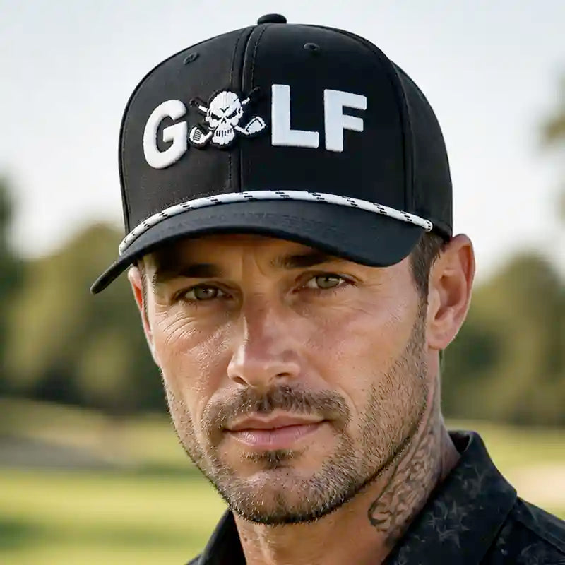 Man wearing a black Tattoo Golf GOLF Tri-Tech performance golf hat with GOLF text and a skull-and-golf-clubs graphic, on a golf course.