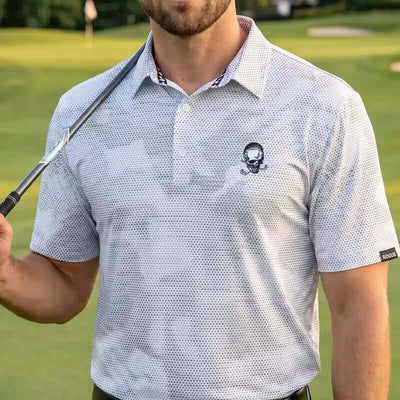 Man wearing a white rogue patterned polo shirt with a skull design on a golf course