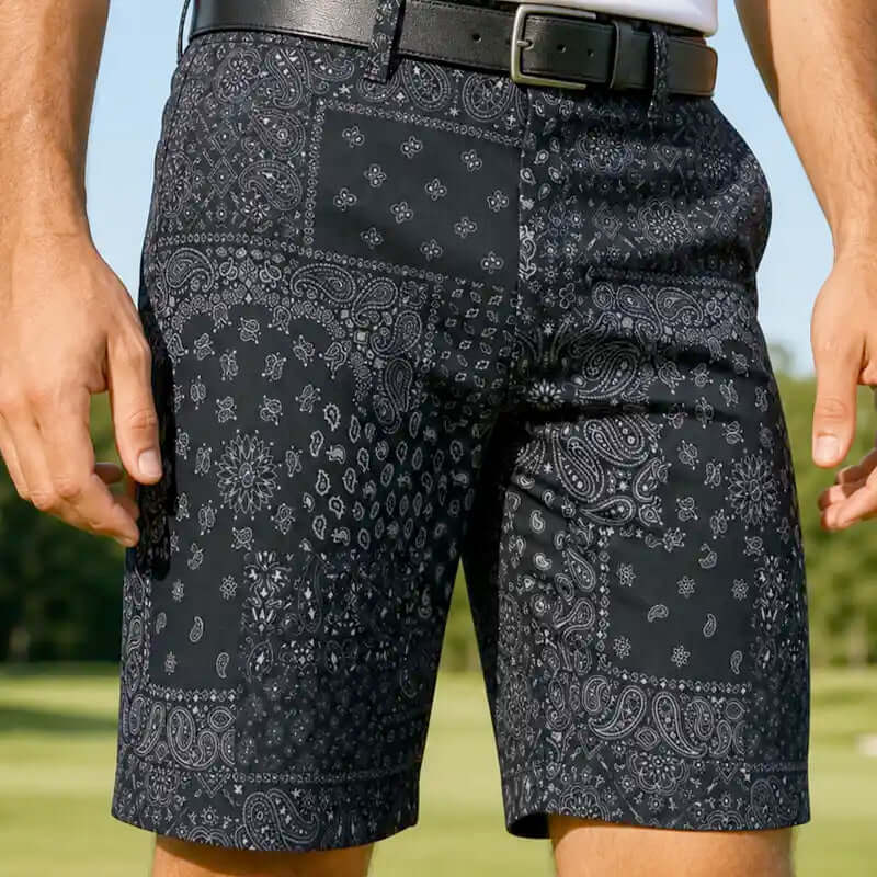 Black patterned golf shorts worn by a person outdoors