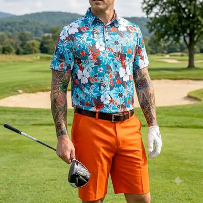 Man in colorful floral shirt and orange shorts holding a golf club on a golf course.