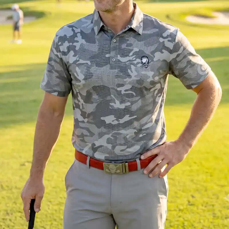 golfer wearing a camouflage polo shirt and red golf belt on a golf course