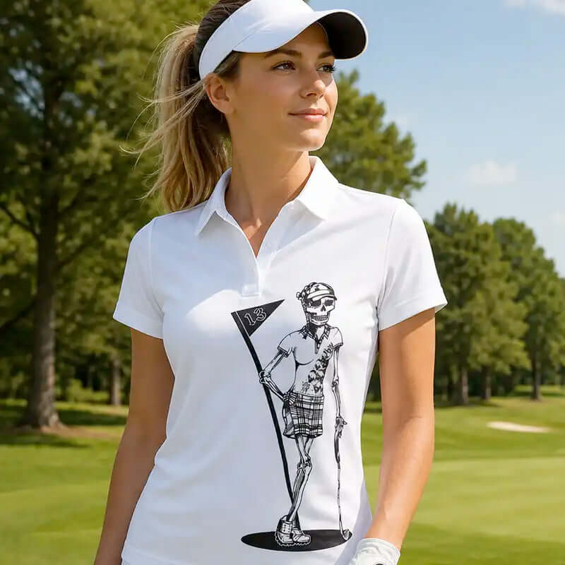 Woman wearing a white polo shirt with a graphic design on a golf course