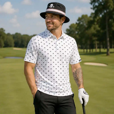 golfer on a golf course wearing a patterned shirt, black pants, and a black bucket hat with a skull design.