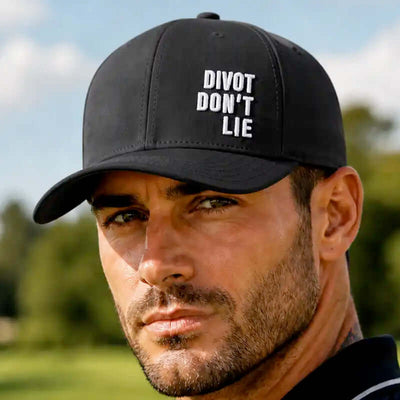 A golfer wearing a black golf cap with white embroidered text reading 'DIVOT DON'T LIE' outdoors.
