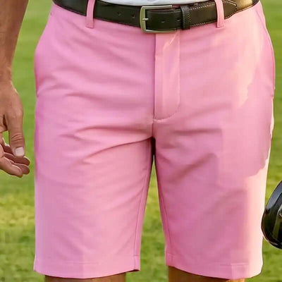 Person wearing pink golf shorts with a black belt 