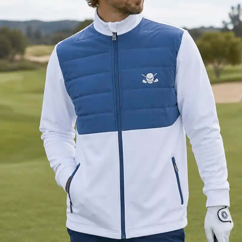 man wearing a blue and white golf jacket with a skull logo on a golf course