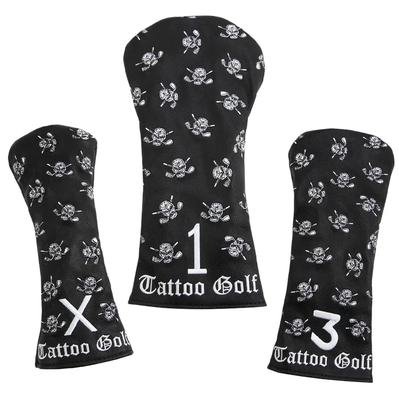 Three black faux-leather golf club covers with embroidered designs including a skull and crossed clubs, and the Tattoo Golf brand logo.