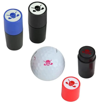 A set of golf ball stampers with a skull design, in black, blue, and red colors, displayed with a white golf ball and a black cap.