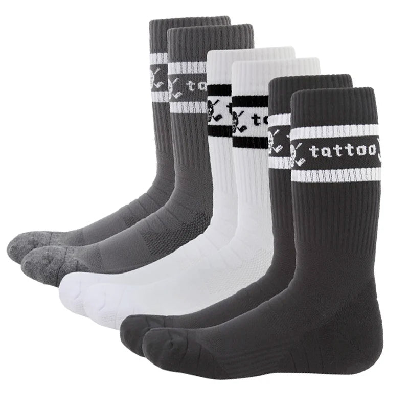 Three pairs of crew-cut golf socks, two in black and one in white, all featuring a skull and crossed clubs logo on the instep and the word 'tattoo' on the back. 
