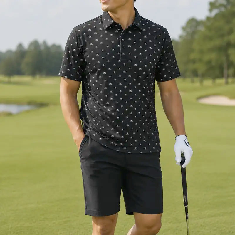 Man in black patterned polo shirt and shorts holding a golf club on a golf course.