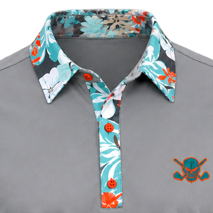 Close-up of a grey VIP polo showing its floral collar and placket, orange buttons and teal-and-orange chest logo.
