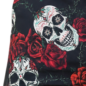 Detail of white sugar skulls, red roses and green leaves printed on black fabric.
