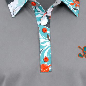 Detail of the teal floral placket and orange buttons on a grey VIP polo.
