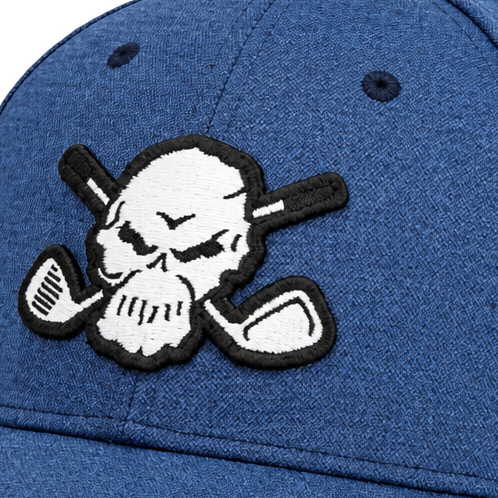 Close-up of a white skull-and-crossed-clubs patch on blue cap fabric.