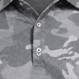 Detail of the buttons and placket on a grey camouflage polo.