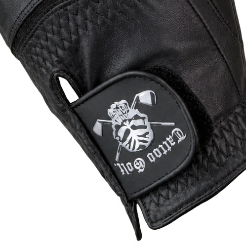 Close-up of a black glove's Tattoo Golf skull wrist patch.