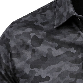 Detail of the shoulder, collar and dark grey camouflage pattern on a golf polo.