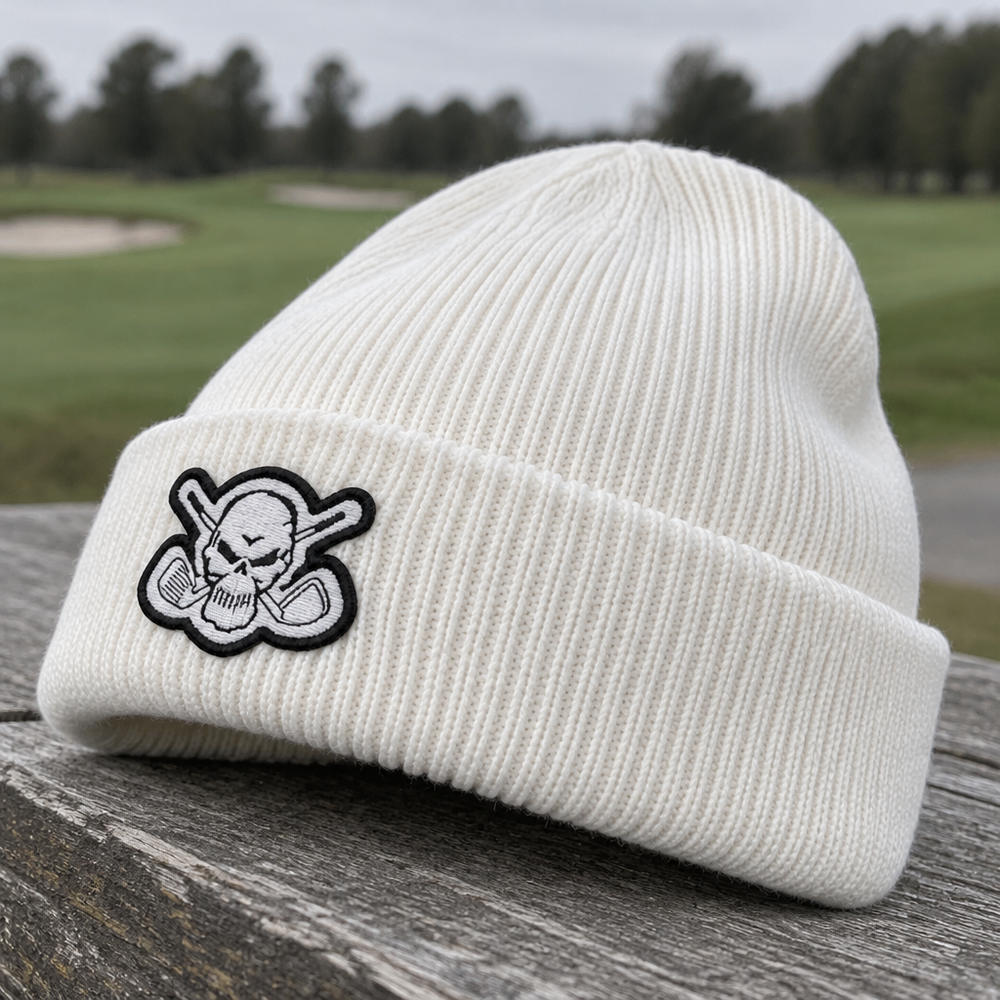 White skull-patch beanie resting on a weathered wooden bench.