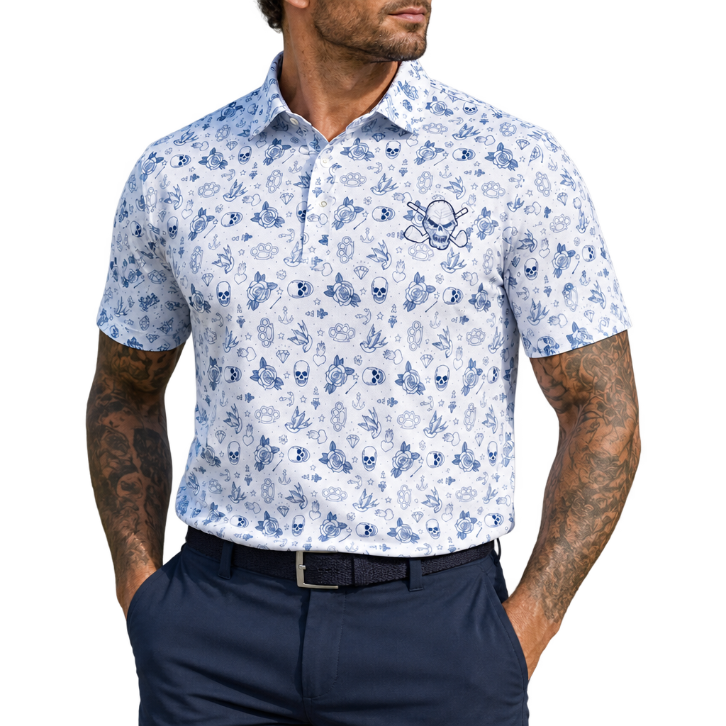 Man wearing a white golf polo with blue tattoo-style graphics and a skull chest logo, paired with navy trousers.
