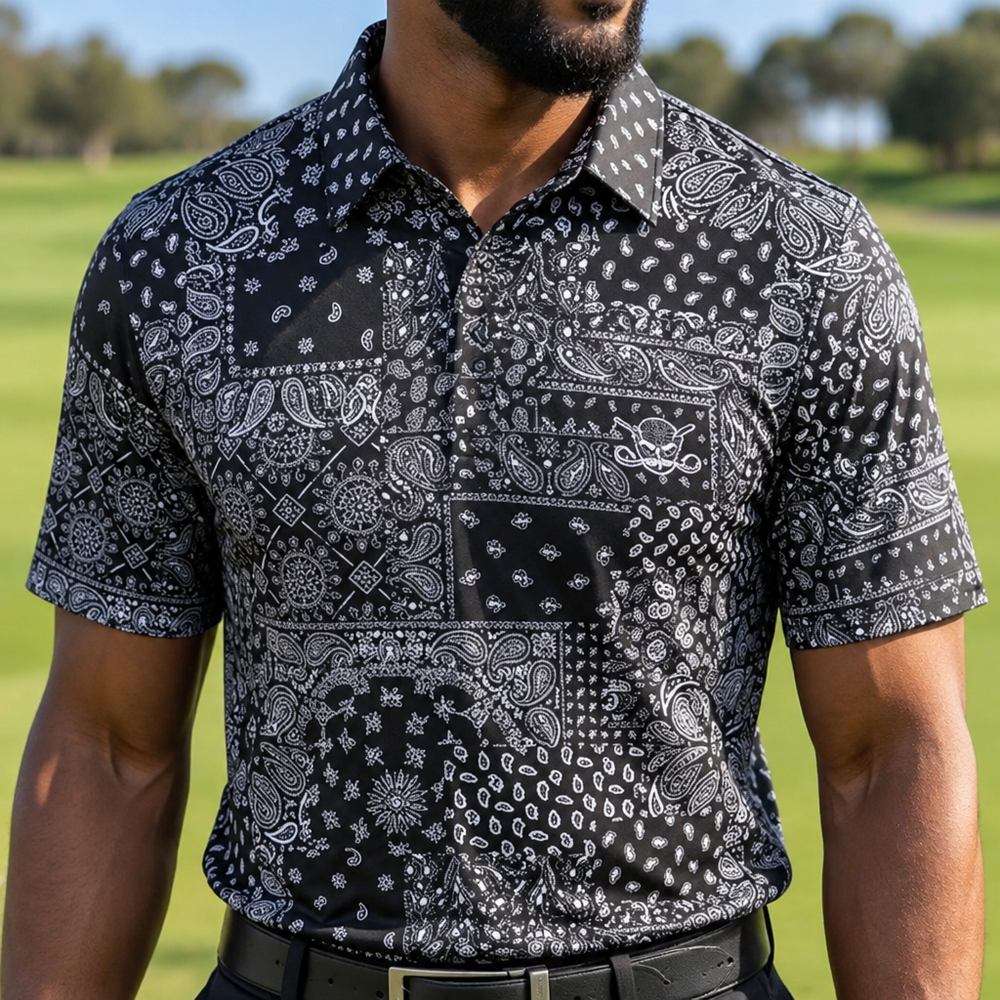 Close-up of a black and grey bandana-print polo worn on a golf course.