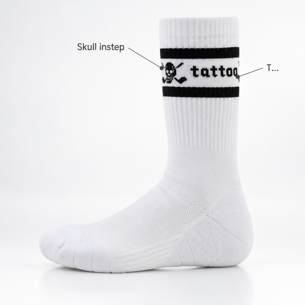 White crew sock with black stripes, skull motif and Tattoo lettering, shown with annotation arrows.