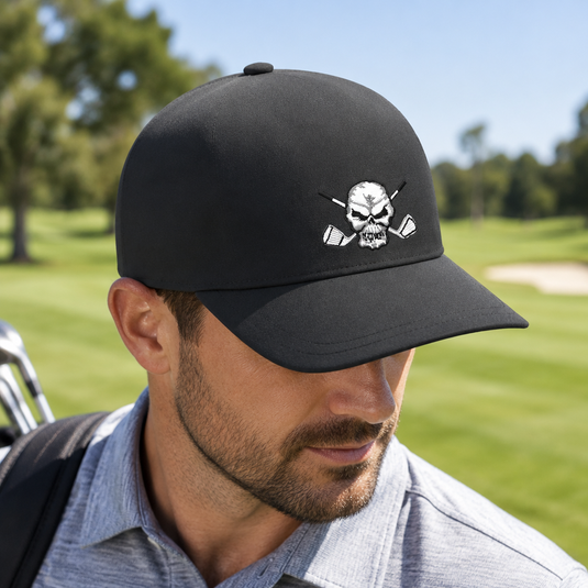 Golfer wearing a black skull-logo cap and grey polo.
