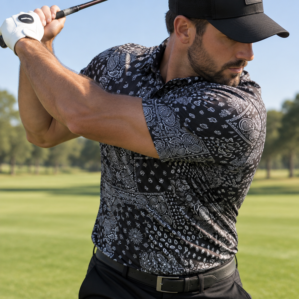 Golfer swinging a club in a black and grey bandana-print polo and black cap.