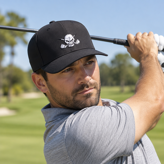 Golfer finishing a swing while wearing a black skull-logo cap.