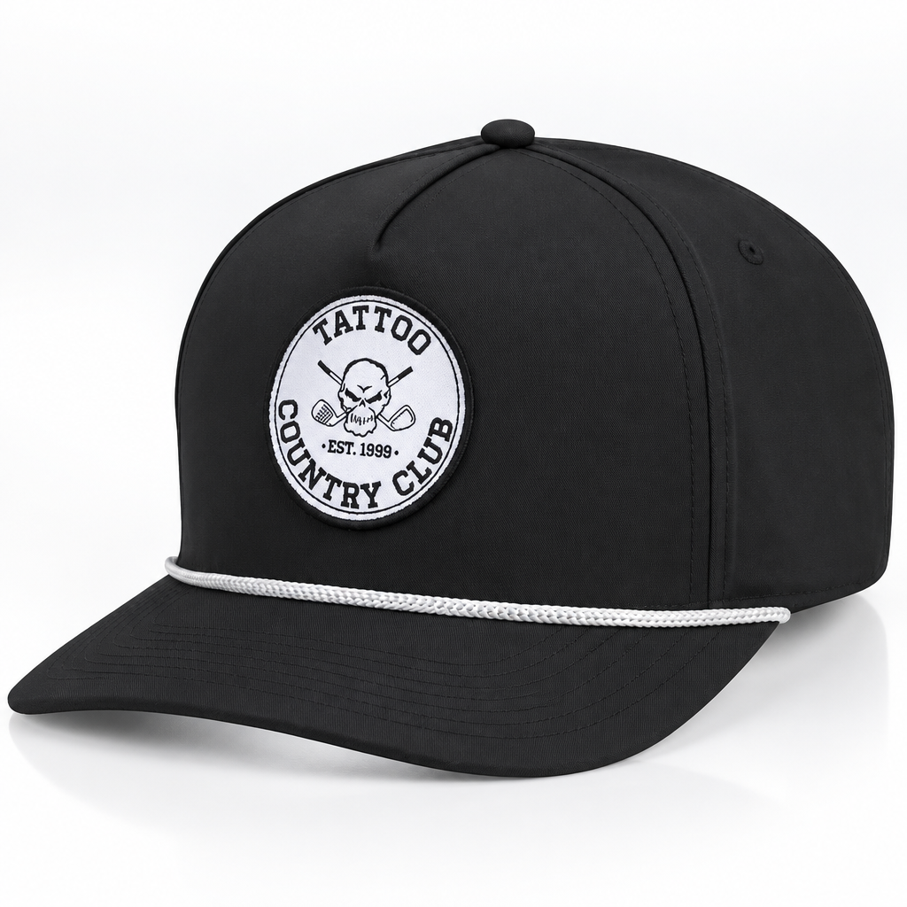 Black Tattoo Country Club golf hat with a white circular skull-and-crossed-clubs patch and white rope trim above the brim.