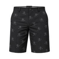 Front view of black golf shorts with grey skull-and-crossed-clubs motifs on a white background.