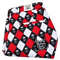 Folded red, white and black argyle polo with skull motifs and a Tattoo Golf chest emblem.