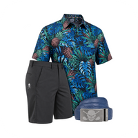 Blue tropical-leaf and pineapple polo displayed with charcoal shorts and navy skull-buckle belt.