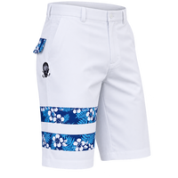 Angled view of white golf shorts showing blue floral leg bands, patterned pocket trim and a small skull logo.