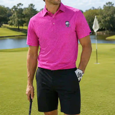 Person wearing a pink polo shirt and black shorts on a golf course