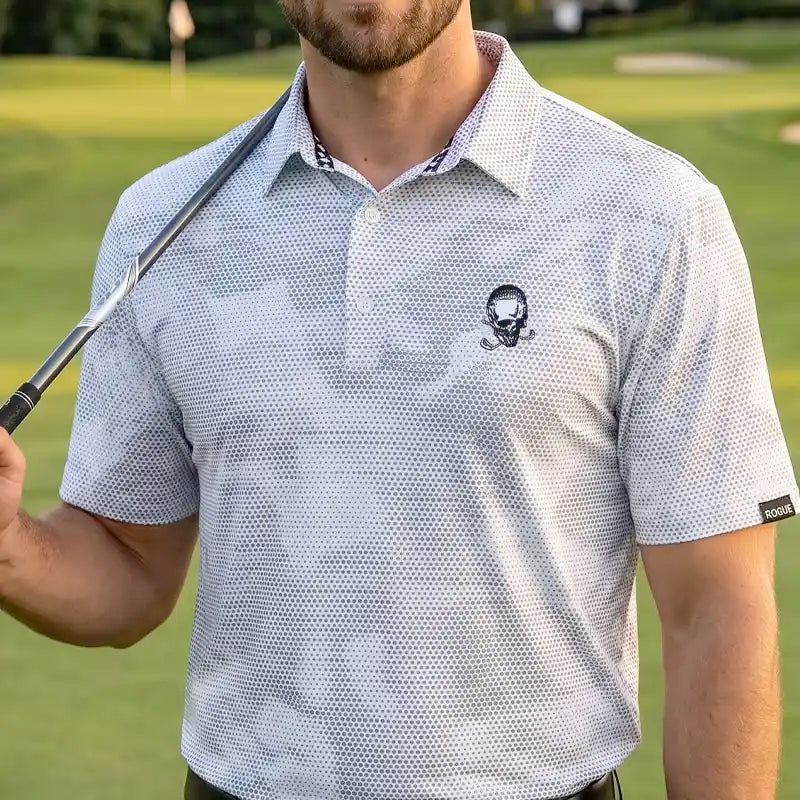 Man wearing a white rogue patterned polo shirt with a skull design on a golf course